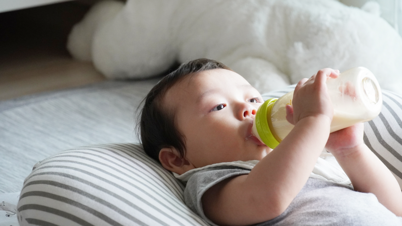 消毒した哺乳瓶のミルクを飲む赤ちゃん